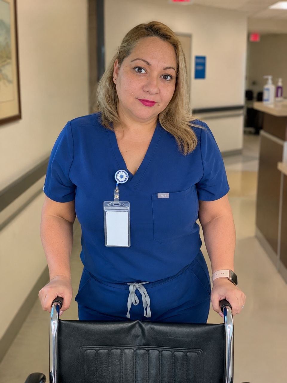 SurgeryRide team member with wheelchair in a medical hallway